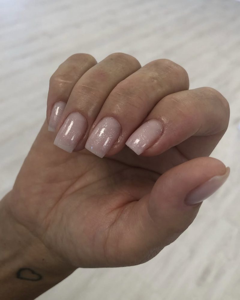 Korta fyrkantiga naglar i nude med ett fint glitter
